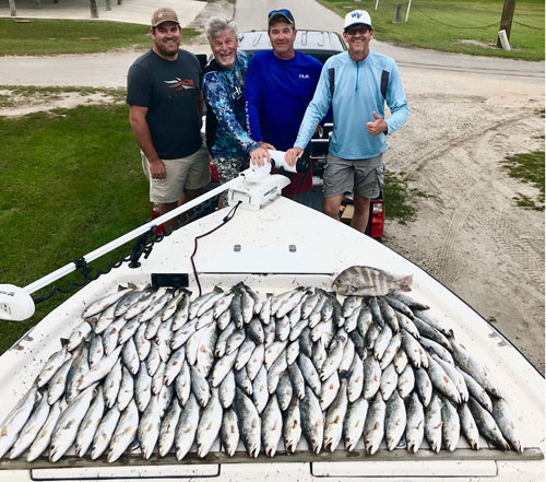 Happy clients with their speckled trout haul.
